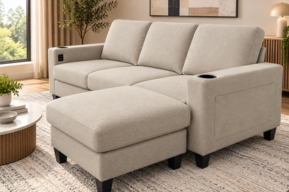 A light beige upholstered sectional sofa with a chaise ottoman in a modern living room setting.